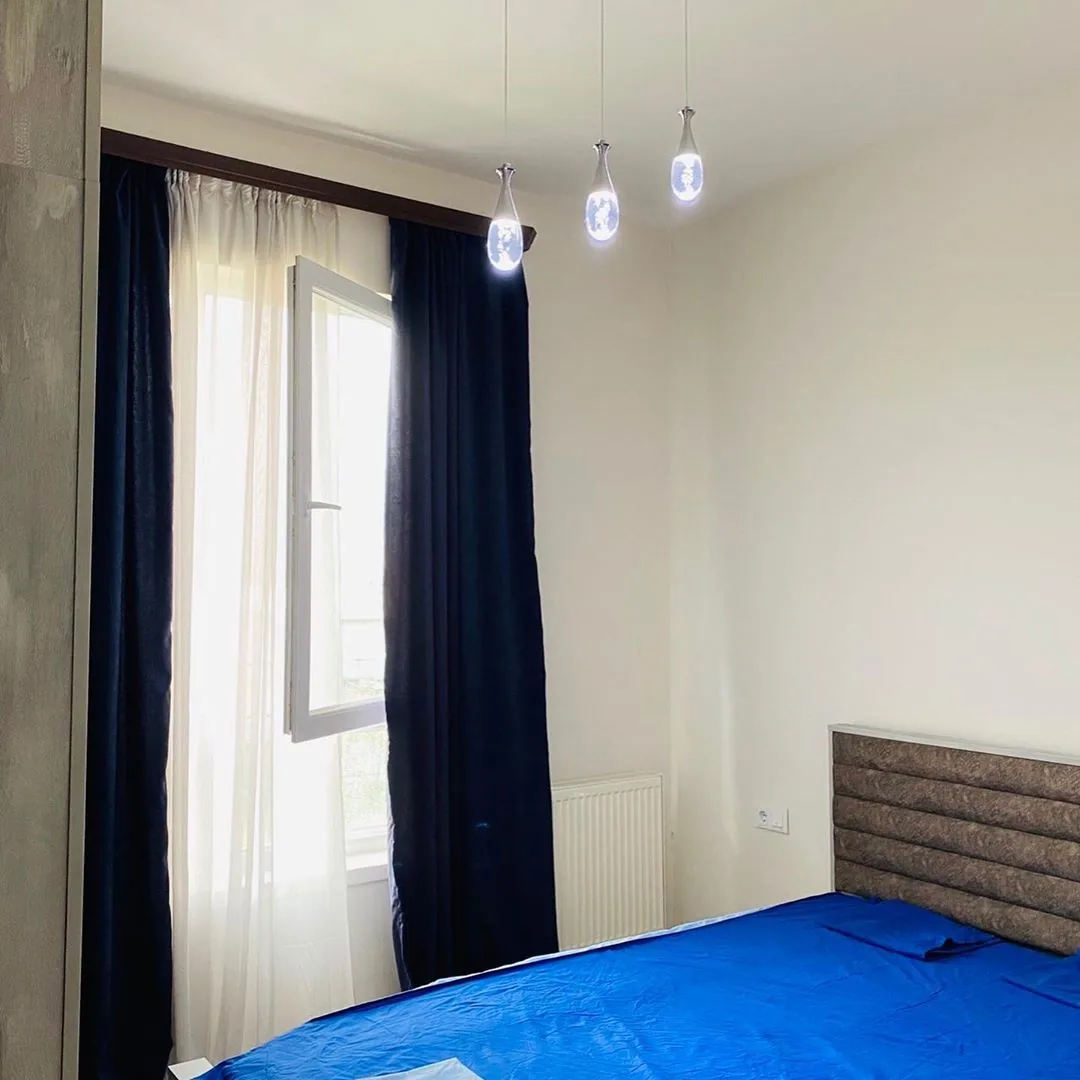 Apartment bedroom with a blue bedspread and window