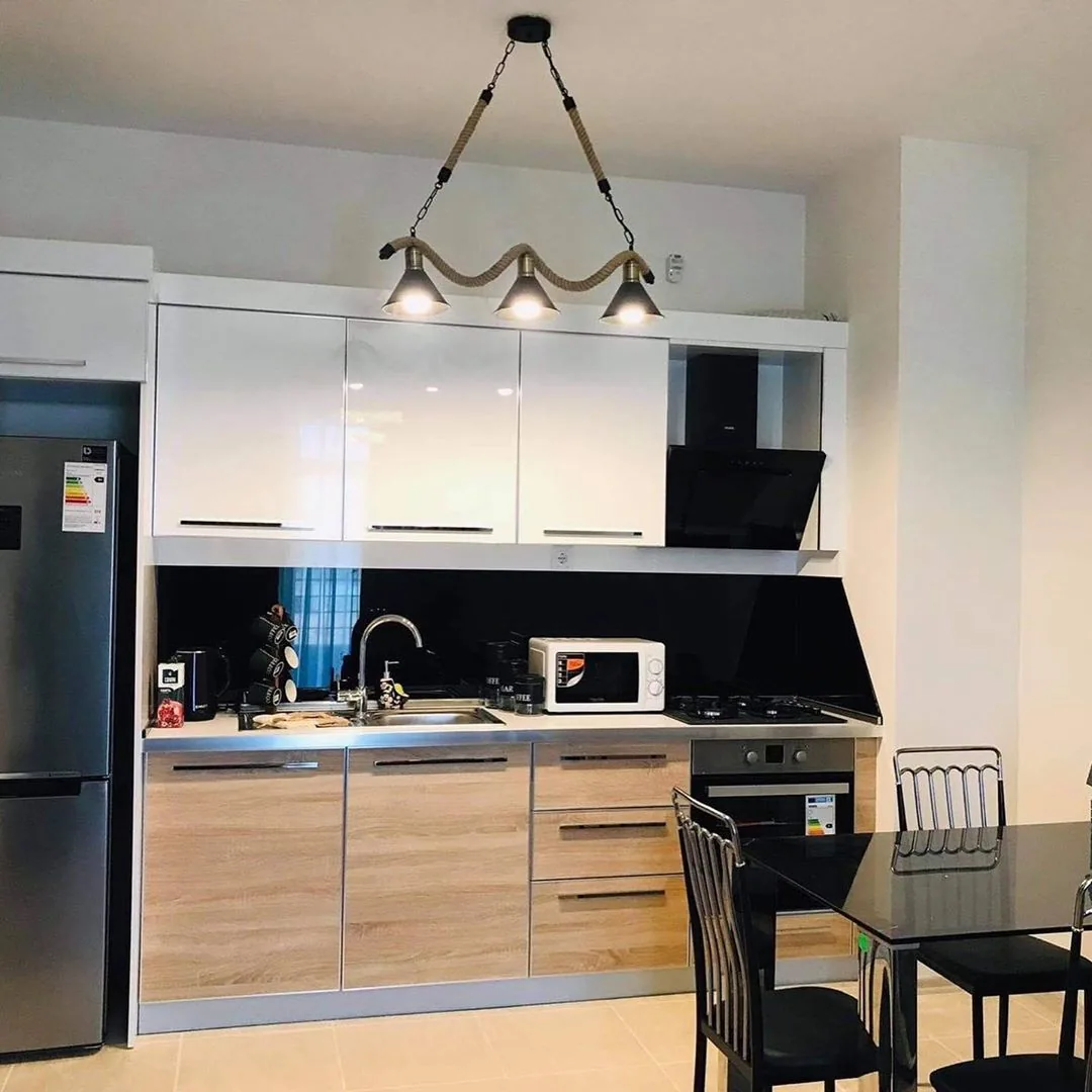 Apartment kitchen with cabinets, appliances and a dining area
