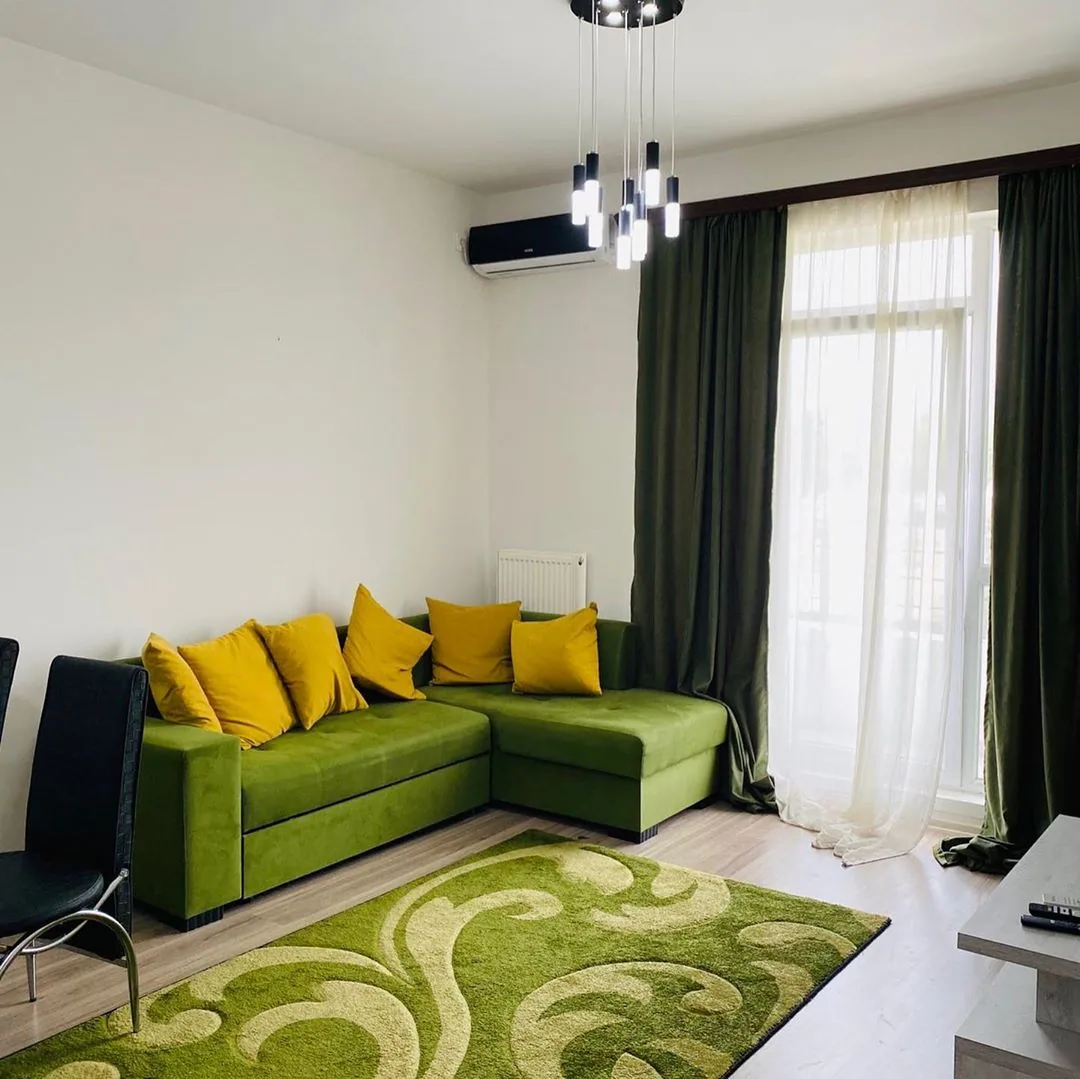 Apartment living room with a green sofa and a large window